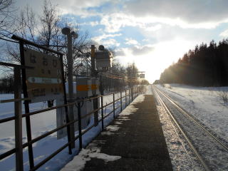 羽帯のホームと駅名標。人はいないが近くの国道を通る車は多い。