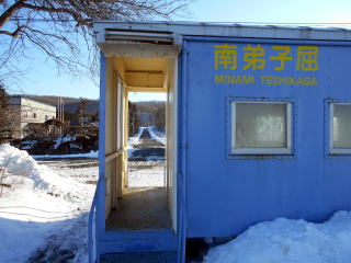 南弟子屈のホームから見た駅前通り。坂を上り切った交差点に小さな商店がある。