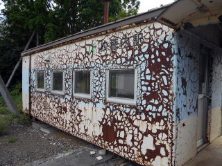 塗装がはがれて錆が出てきている紋穂内の待合室の外壁。ここまで来るとある意味アートである。