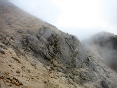 白い岩・砂の斜面にガスがたなびく
