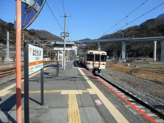 波高島に到着する身延線の電車。背後の高速道路には下部温泉の玄関口の役割を担うインターチェンジも設けられている。