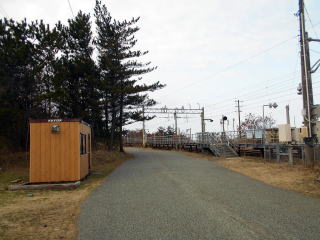 桂根のホーム入口、道路のはす向かいにあるプレハブ小屋が待合室である。