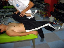 写真１４　トーマステストでの評価　股関節、膝が屈曲し大腿が外を向いている